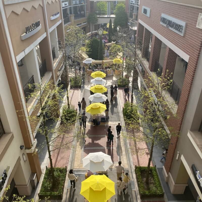 아울렛-2층에서-내려다-본-풍경-흰색과-노란색-파라솔이 -교차되어-배치되어있음